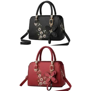Close-up of faux leather texture with floral embroidery and metal bow charm details