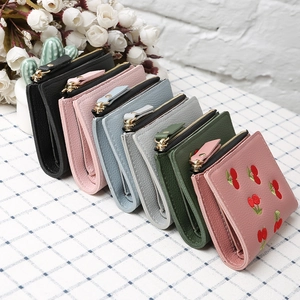 Detailed view of colorful cherry embroidered small wallets in various pastel shades