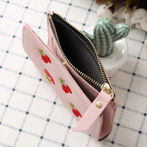 Pink faux leather wallet with cherry embroidery and gold zipper in a minimalist design