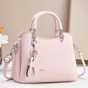 Pink lychee grain shoulder bag with star charm and silver hardware on white background