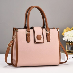 Sac bandoulière en cuir grainé rose avec poignées marron et détails dorés brillants