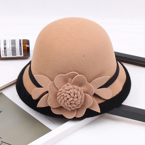 Detalle de sombrero cloche de lana camello con flor 3D y borde negro decorativo