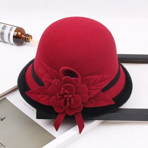Detail of red wool felt hat with black faux fur brim and oversized floral ornament