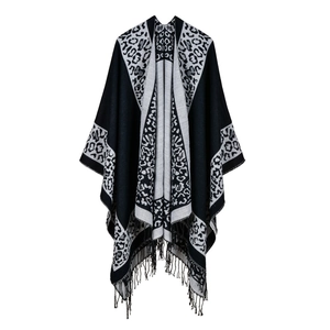 Classic black and white leopard print knit shawl cape with fringe tassels on white background
