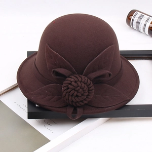 Detail of wool felt floral decoration on brown cloche hat with textured fabric
