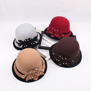 Detail of wool cloche hats in multiple colors featuring 3D flower and pearl ornaments
