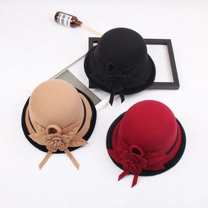 Detailed close-up of wool cloche hats in black, camel, and red with floral accents