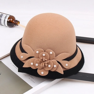 Detail of wool felt cloche hat featuring handmade flower decor with white pearls