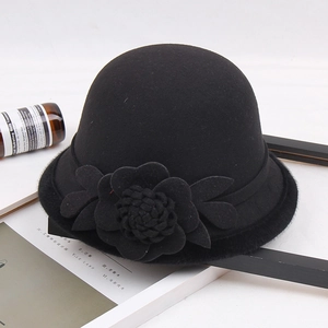Detalle de sombrero cloche de lana negra con decoración de flores en 3D hechas a mano