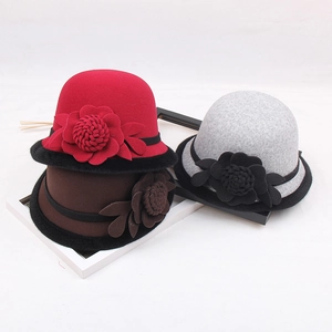 Detalle de sombreros cloché de fieltro de lana para mujer con flores en rojo, marrón y gris