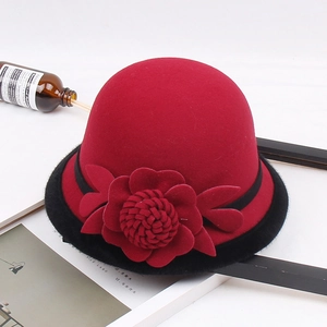 Detalle de un sombrero cloche de lana roja con ribete de piel sintética negra y flor en 3D