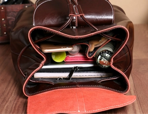Detailed view of the large capacity interior of a brown leather backpack with organizers
