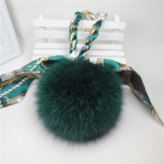 Detailed view of soft dark green mink fur pompom keychain with elegant floral silk ribbon