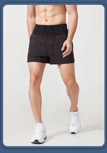 Detail of men's quick-dry sports shorts showing black woven fabric and elastic drawstring waist