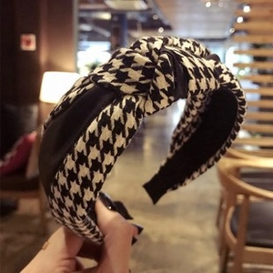 Detail of the houndstooth pattern fabric and top knot design on a wide fashion headband