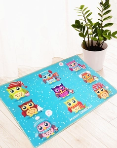 Detail of blue Christmas owl rug with Merry Christmas text on wooden floor