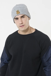Detail of grey knitted beanie featuring yellow and green monkey embroidery patch