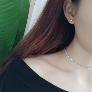 Close-up of 925 silver four-claw zircon earrings and matching tennis necklace set