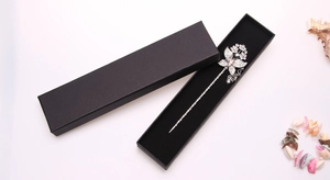 Detailed view of floral silver hair pin with pink gems in black rectangular jewelry box