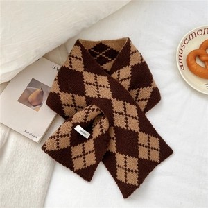 Close-up of wool argyle scarf with classic brown patterns on a white fabric background