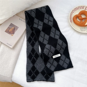 Detail of cross-style argyle knit scarf in 100% wool showing soft texture and pattern
