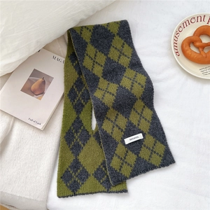 Detail of 100% wool knitted scarf showing green and grey argyle pattern texture
