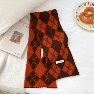 Detail of 100% wool knitted scarf with argyle pattern and cross opening design