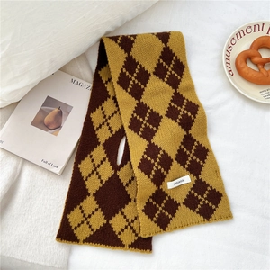 Detail view of double-layer knit scarf with yellow brown argyle pattern and wool texture