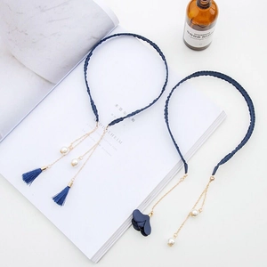 Detail of navy woven headbands with elegant pearl tassels and 3D floral accents