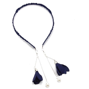 Detail of dark blue fabric headband featuring metal chains with flower tassels and pearls
