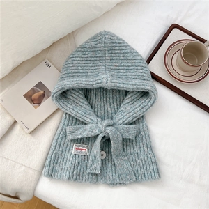 Detailed close-up of light blue knitted balaclava hood with tie bow and white button
