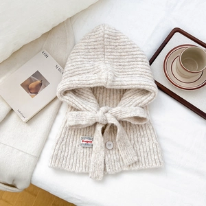 Detail of cream knit hood scarf with button closure and adjustable drawstring ties