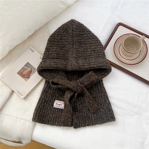 Close-up of chunky knit neck warmer hood in dark coffee blend with decorative bow