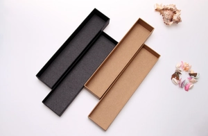 Detail of long kraft paper jewelry boxes in black and natural colors with seashell decor