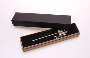 Detail of silver rhinestone butterfly hair pin inside a rectangular kraft gift box