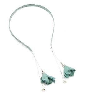 Detail of teal fabric flower tassel necklace with elegant white pearls and metal chains