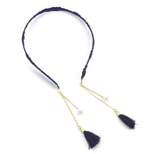 Detail of dark blue knitted headband with golden chains, pearls and tassel charms