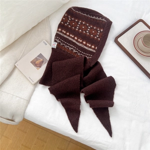 Close-up of Fair Isle knit hooded scarf in brown with cozy home lifestyle setting