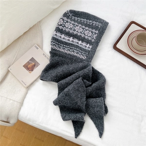Close-up of a grey knitted balaclava hood featuring Nordic jacquard patterns and long scarf