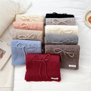 Soft knitted bow scarves in multiple colors including red and blue for winter warmth