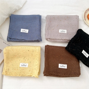 Flachbild von fünf verschiedenfarbigen Strickschals aus Melangegarn mit Logo-Patch