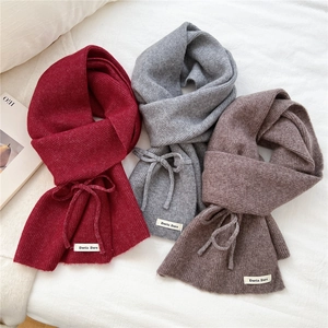 Detail view of knitted scarves with soft rib texture and signature brand label