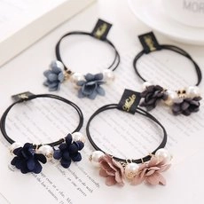 Detailed close-up of colorful matte flower hair ties with elegant pearls and elastic bands