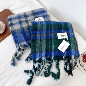 Close-up of thick striped knit scarves with chunky hand-woven tassels and soft texture