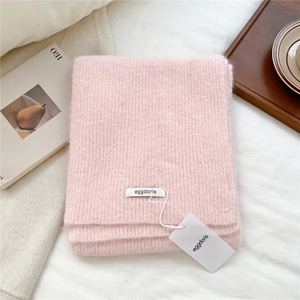Close-up of soft pink wool blend knit scarf with ribbed texture and brand tag