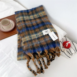 Detailed macro of thick blue and brown plaid scarf featuring soft brushed knit textures
