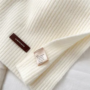 Detailed close-up of ribbed knit texture with brown leather brand tag and care label