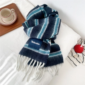 Detailed close-up of a thick striped wool scarf with navy blue and white fringe