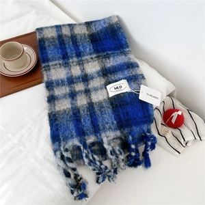 Detailed view of striped tassel scarf in blue and grey plaid with a cozy woolen texture