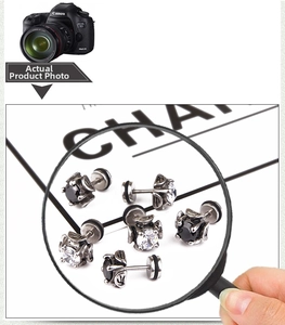 Macro detail of cross zircon stud earrings with black and white stone settings